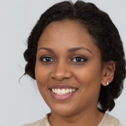 Joyful black young-adult female with long  brown hair and brown eyes