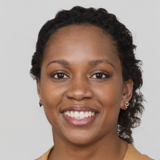 Joyful black adult female with short  brown hair and brown eyes
