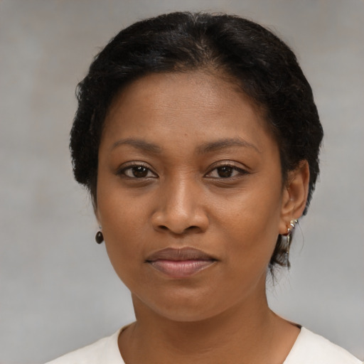 Joyful black young-adult female with short  brown hair and brown eyes