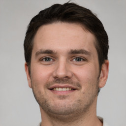 Joyful white young-adult male with short  brown hair and grey eyes