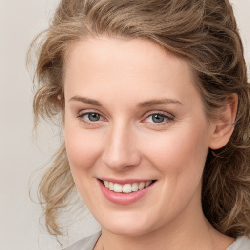 Joyful white young-adult female with medium  brown hair and blue eyes