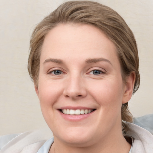 Joyful white young-adult female with medium  brown hair and blue eyes