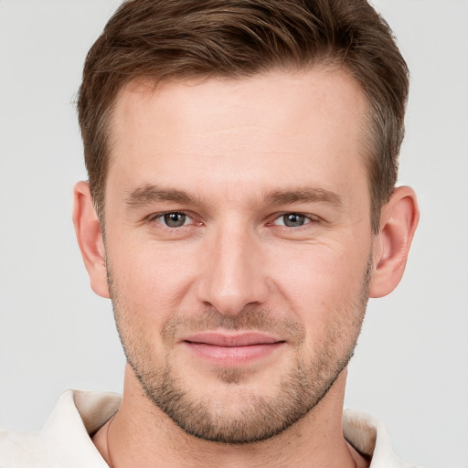 Joyful white young-adult male with short  brown hair and grey eyes