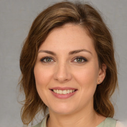 Joyful white young-adult female with medium  brown hair and green eyes