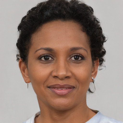 Joyful black young-adult female with short  brown hair and brown eyes