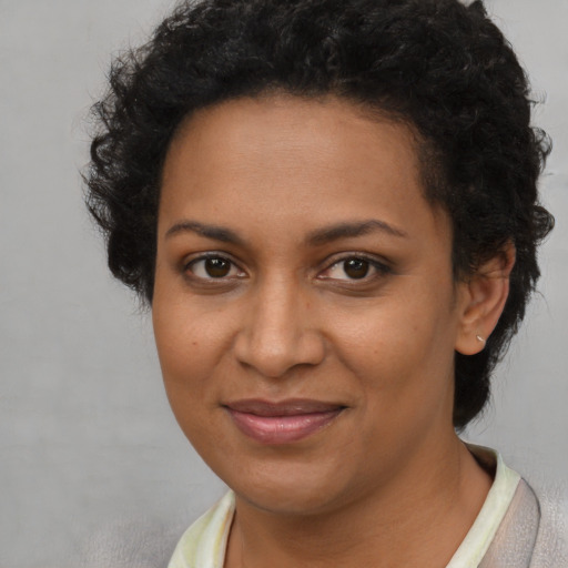 Joyful black young-adult female with short  brown hair and brown eyes