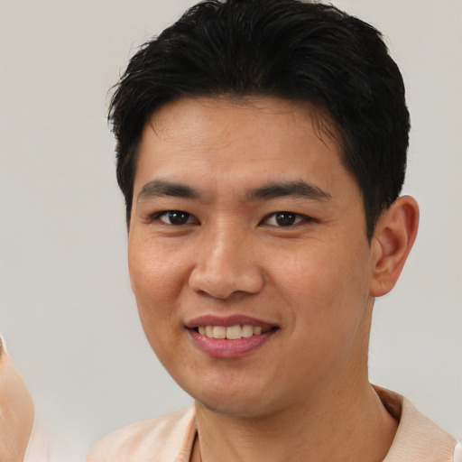 Joyful asian young-adult male with short  black hair and brown eyes