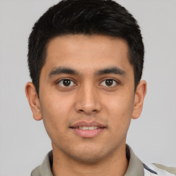 Joyful latino young-adult male with short  brown hair and brown eyes