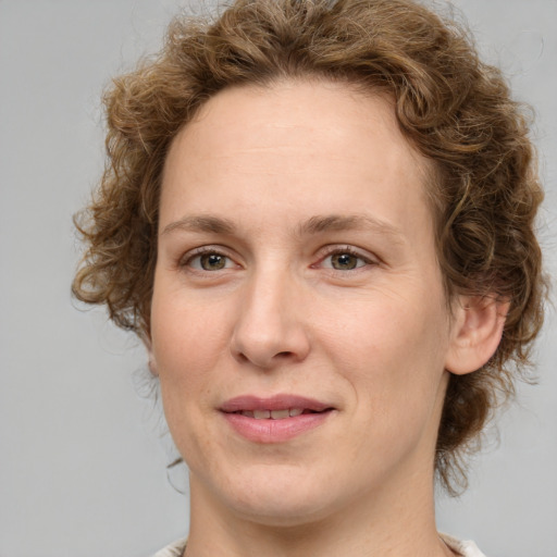 Joyful white adult female with medium  brown hair and green eyes