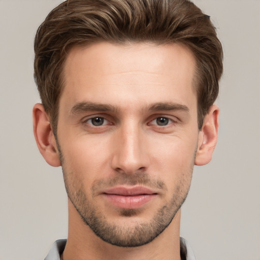 Joyful white young-adult male with short  brown hair and grey eyes