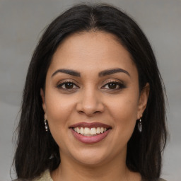 Joyful latino young-adult female with long  brown hair and brown eyes