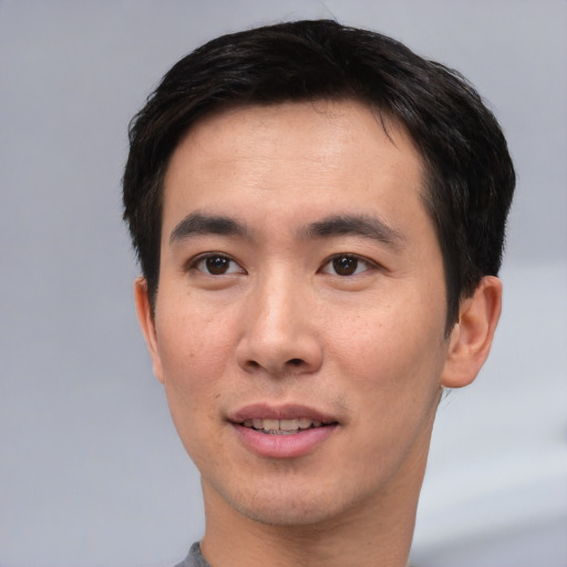 Joyful asian young-adult male with short  black hair and brown eyes