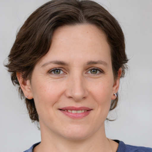 Joyful white adult female with medium  brown hair and grey eyes