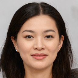 Joyful asian young-adult female with long  brown hair and brown eyes