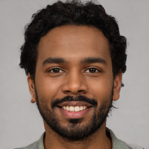 Joyful black young-adult male with short  black hair and brown eyes