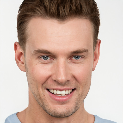 Joyful white young-adult male with short  brown hair and grey eyes