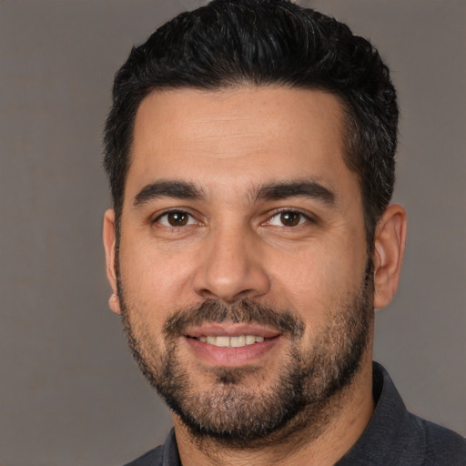 Joyful white young-adult male with short  black hair and brown eyes