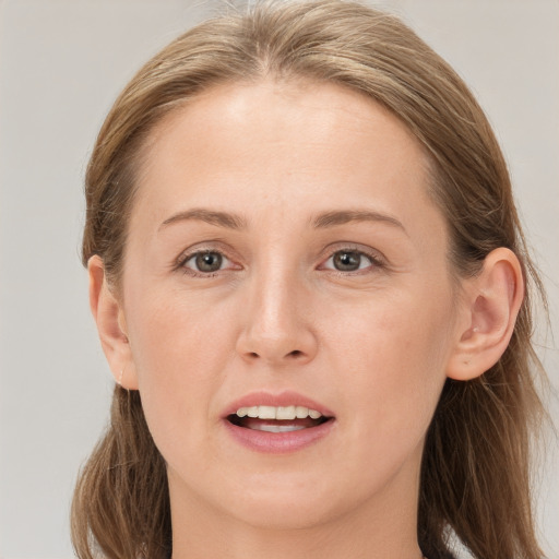 Joyful white young-adult female with long  brown hair and grey eyes