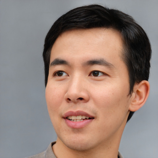 Joyful asian young-adult male with short  black hair and brown eyes