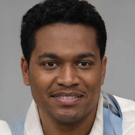 Joyful black young-adult male with short  brown hair and brown eyes