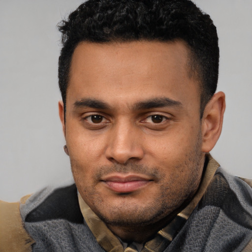 Joyful latino young-adult male with short  black hair and brown eyes