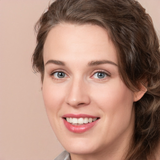 Joyful white young-adult female with medium  brown hair and green eyes