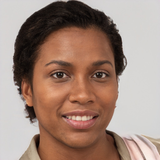 Joyful black young-adult female with short  brown hair and brown eyes