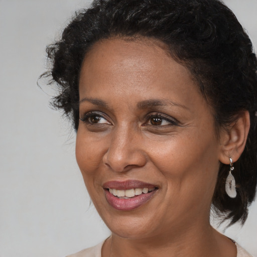 Joyful black adult female with medium  brown hair and brown eyes