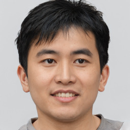 Joyful asian young-adult male with short  brown hair and brown eyes