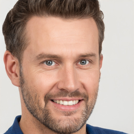 Joyful white adult male with short  brown hair and grey eyes