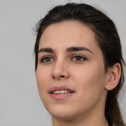 Joyful white young-adult female with long  brown hair and brown eyes