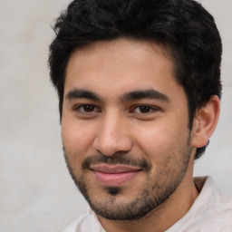 Joyful latino young-adult male with short  brown hair and brown eyes