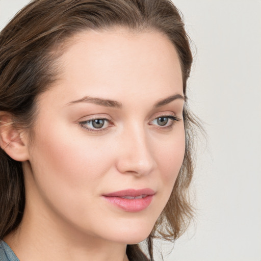 Joyful white young-adult female with long  brown hair and blue eyes