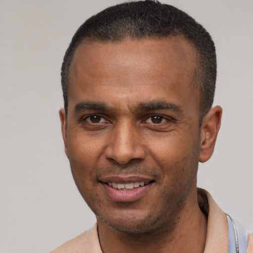 Joyful latino young-adult male with short  brown hair and brown eyes