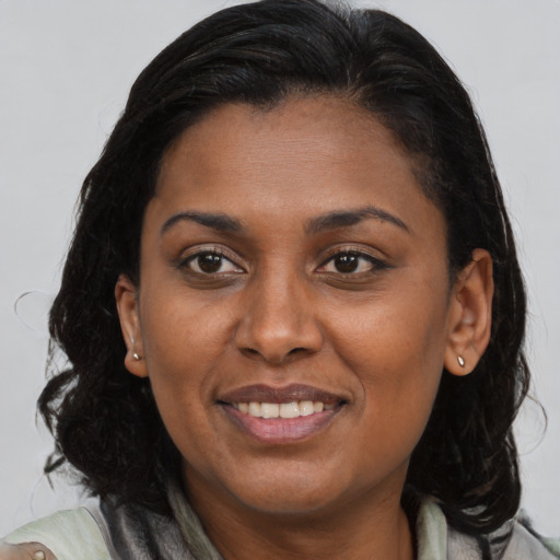 Joyful black adult female with medium  brown hair and brown eyes