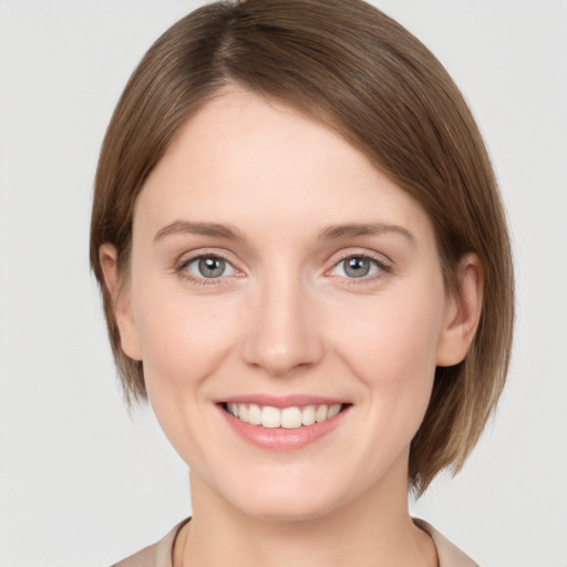 Joyful white young-adult female with medium  brown hair and grey eyes