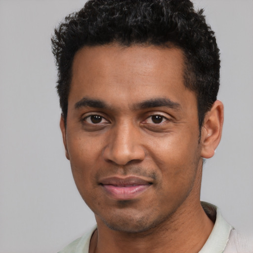 Joyful black young-adult male with short  black hair and brown eyes