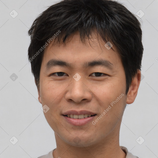 Joyful asian young-adult male with short  brown hair and brown eyes