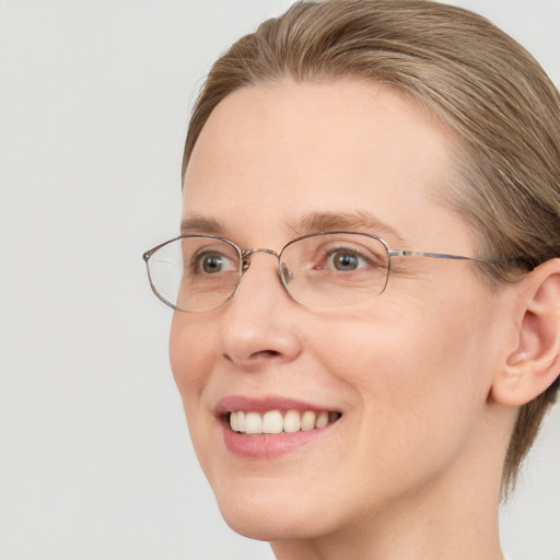 Joyful white adult female with medium  brown hair and blue eyes