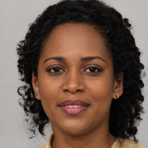 Joyful black young-adult female with long  black hair and brown eyes