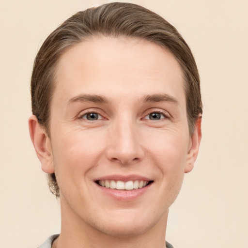 Joyful white young-adult male with short  brown hair and grey eyes