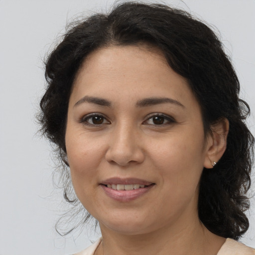 Joyful latino adult female with medium  brown hair and brown eyes
