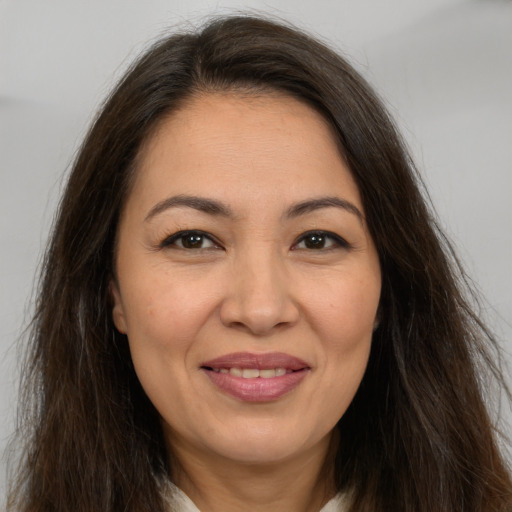 Joyful white adult female with long  brown hair and brown eyes