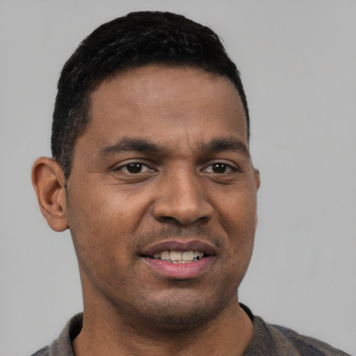 Joyful latino young-adult male with short  brown hair and brown eyes