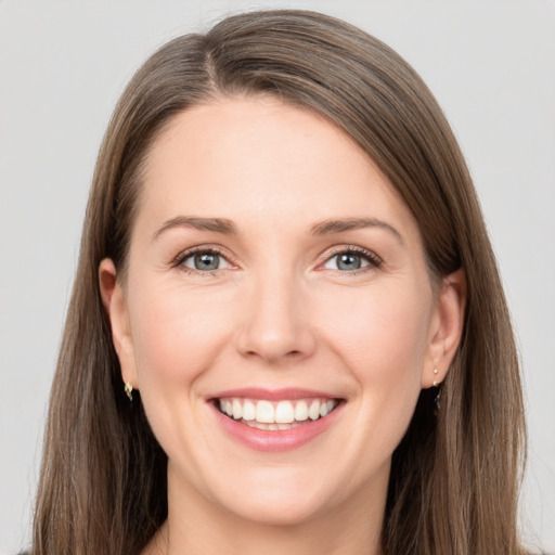 Joyful white young-adult female with long  brown hair and grey eyes