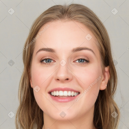 Joyful white young-adult female with long  brown hair and blue eyes