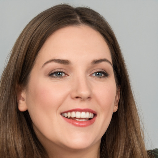 Joyful white young-adult female with long  brown hair and grey eyes