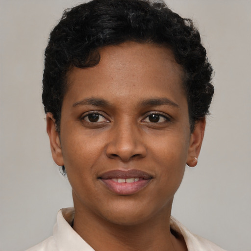 Joyful black young-adult female with short  black hair and brown eyes