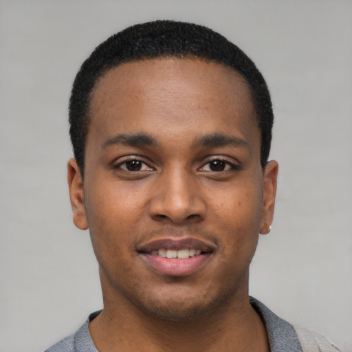 Joyful black young-adult male with short  black hair and brown eyes