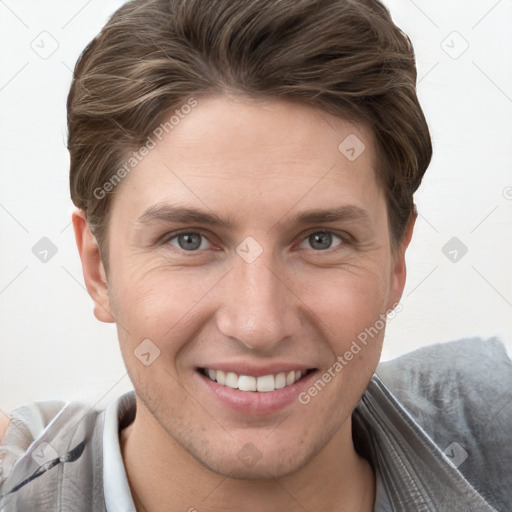 Joyful white young-adult male with short  brown hair and grey eyes